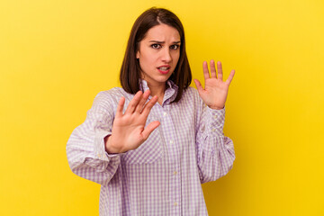 Young caucasian woman isolated on yellow background being shocked due to an imminent danger