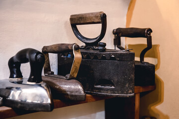 Collection of vintage irons for ironing clothes. Antique metal irons, a museum piece of antique household appliances. Cordless metal charcoal iron.