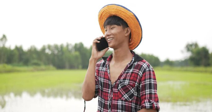 Young farmer man talking on smartphone with feels happy