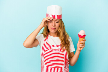 Caucasian ice cream maker woman holding an ice cream isolated on blue background being shocked, she has remembered important meeting.