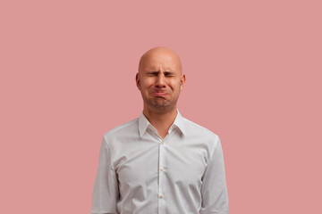 Crying like a child. Desperate bald man has sorrowful expression, cries as a little boy whose...