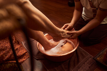 Woman washing foot in special container in spa salon
