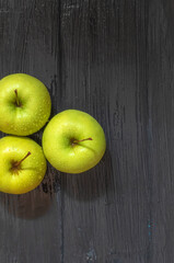 Fresh apples of yellow green color of a small size on a wooden background