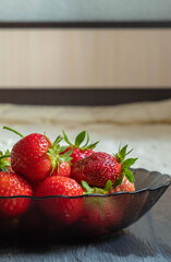 Side view of juicy and ripe garden strawberries, which lies in a glass plate