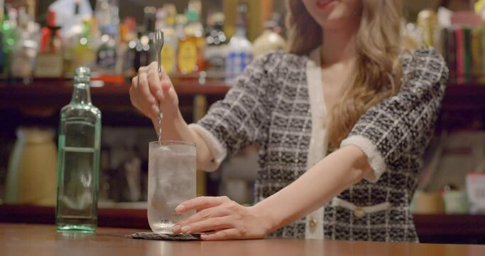 Young woman providing alcohol in counterbar