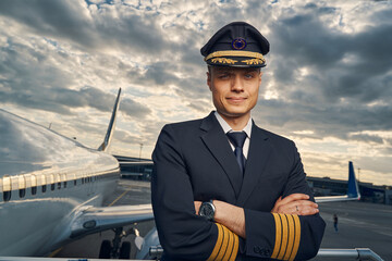 Serious aviator posing for the camera before the flight - obrazy, fototapety, plakaty