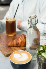 Obraz na płótnie Canvas Drinking espresso tonic, trendy coffee drink with croissant