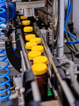 Plastic bottles on capping machine in pharmaceutical laboratory