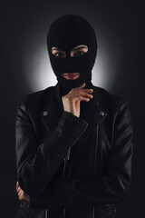 Woman wearing knitted balaclava on black background