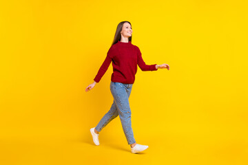 Full length body size view of attractive cheerful girl walking strolling isolated over bright yellow color background