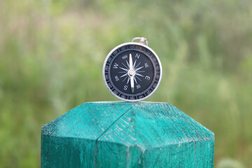 Classic navigation compass on natural background as symbol of tourism with compass, travel with...