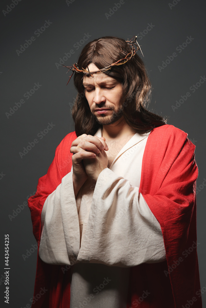 Wall mural jesus christ with crown of thorns praying on grey background