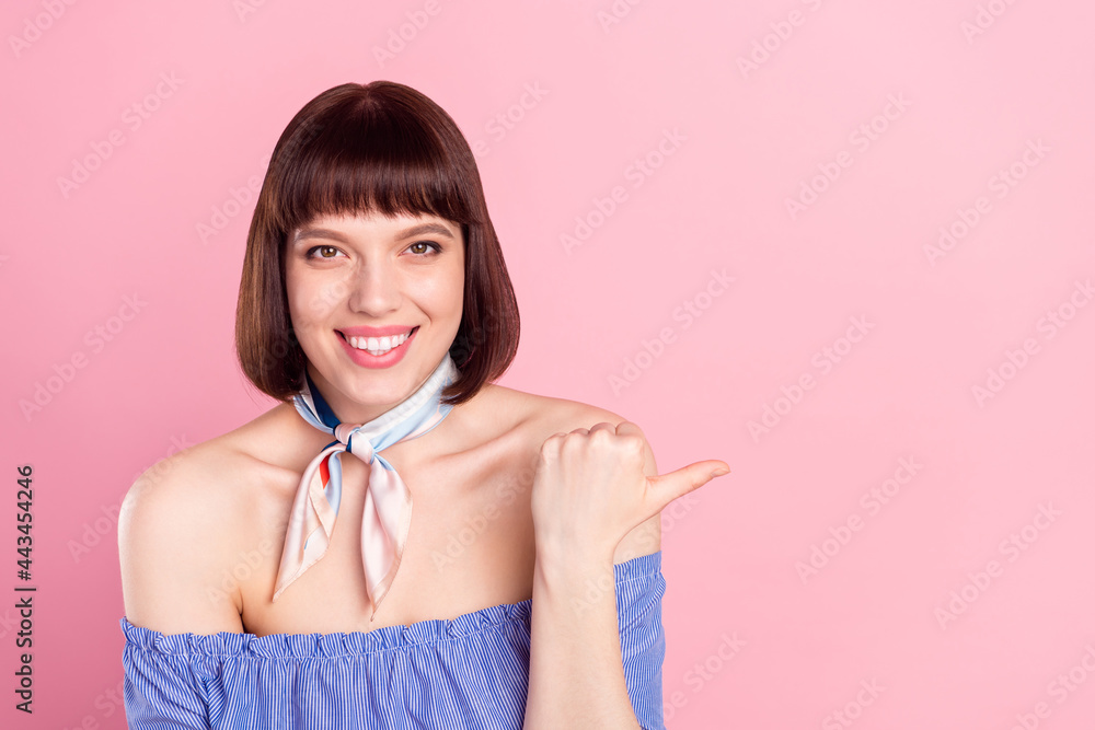 Poster Photo of cheerful nice happy young woman point finger thumb empty space sale isolated on pink color background