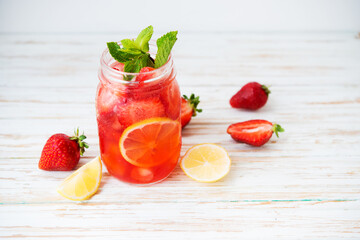 Cold summer strawberry lemonade in a jar on a white background, selective focus - obrazy, fototapety, plakaty
