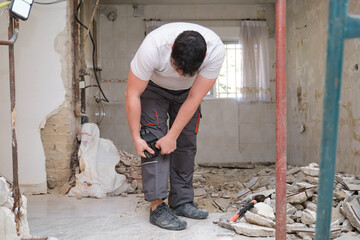 Young builder wearing knee protection pads to work in a construction. Safety at work.