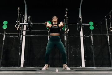 Woman performing a weightlifting exercise inside a gym