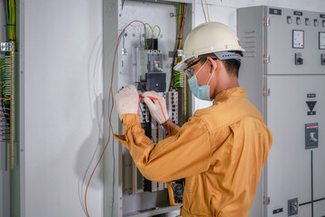 Electrical engineer inspects the electrical system in the factory. Electrician is repairing a factory electrical system. Electrical maintenance in the factory by electrical engineer.