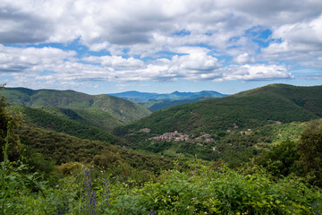 Fototapeta na wymiar View into the landscape of the French Cevennes towards Saint Martial. Cloudy summer sky