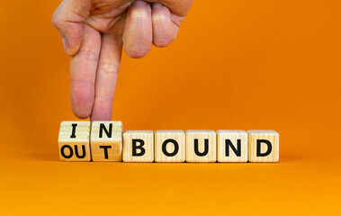 Inbound or outbound symbol. Businessman turns wooden cubes and changes the word 'outbound' to 'inbound'. Beautiful orange table, orange background. Business, inbound or outbound concept. Copy space.