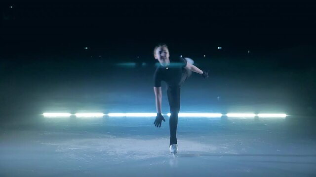 Young girl is doing a camel spin while skating