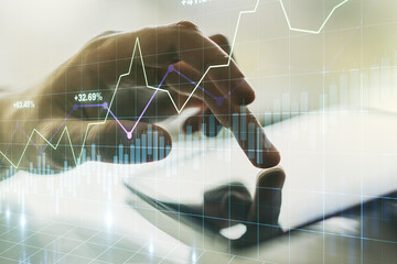 Multi exposure of abstract financial diagram and hand working with a digital tablet on background, banking and accounting concept