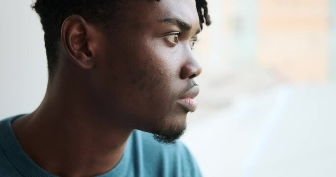 African american man looking out through window