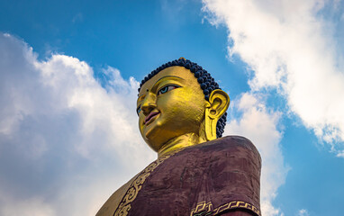 huge buddha golden statue from different perspective with bright blue sky at evening