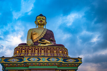 huge buddha golden statue from different perspective with moody sky at evening