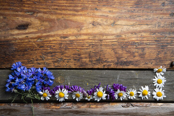 Ramka z kwiatów na tle drewnianych starych desek