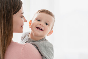 Toothy smile of a little small kid child, embracing his mother nanny babysitter. Happy moments of...