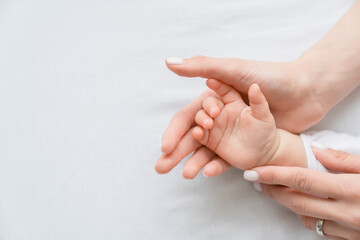 Close up image of a mother`s mom hand holding her little small toddler`s infant newborn tiny hand...