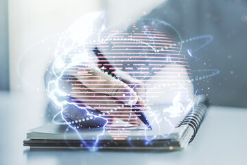 Double exposure of abstract digital world map with connections and man hand writing in notepad on background, big data and blockchain concept