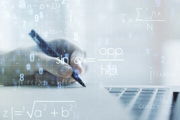 Creative scientific formula concept with hand writing in notebook on background with laptop. Multiexposure