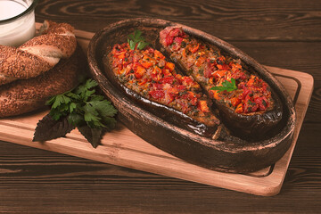 Turkish dish, Imam Bayildy, stuffed eggplant, karnyaryk, homemade, on a wooden table, rustic, no people, horizontal,