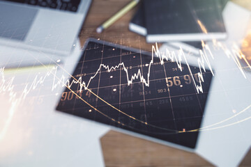 Double exposure of abstract creative financial chart and digital tablet on background, top view, research and strategy concept