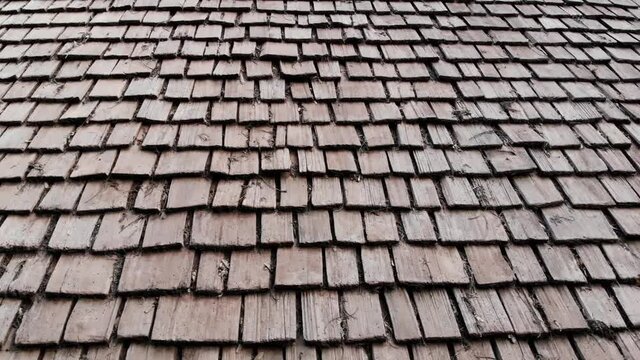 Drone footage flying to the right over a cedar shake shingle roof.