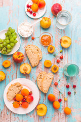 Ciabatta with peach and apricot jam, ricotta cheese, fruits and smoothie