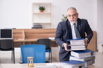 Aged male employee in time management concept