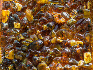 Luminous amber stones. Amber texture. Beautiful background from natural resin. Sun stone as the main background for advertising jewelry. Lamp with lampshade from amber Yellow light. Light throw amber