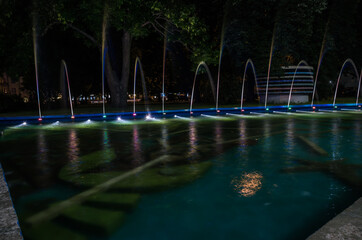 Colorful water fountains. Beautiful laser and fountain show. Large multi colored decorative dancing water jet led light fountain show at night.