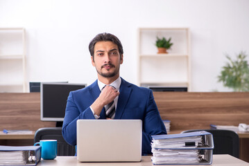 Young male employee and too much work in the office