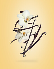 Dried vanilla sticks with flowers in the air on a yellow background