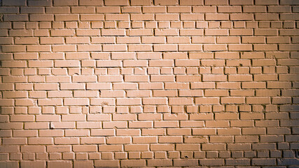 Old brick wall of brown blocks with wide cracks between them