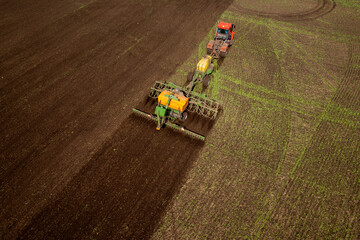 Agriculture Tractor cultivation and plows land of field for planting cereals plough, Aerial top view rural