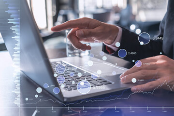 Hands typing the keyboard to research stock market to proceed right investment solutions. Internet trading and wealth management concept. Formal wear. Hologram Forex chart over close up shot.