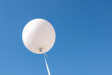 Several white air balloons and a very blue sky in the background
