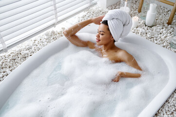 Attractive woman relax in the bath with foam