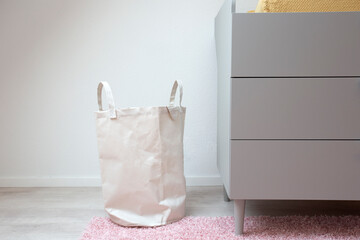 Stylish white laundry basket standing in modern room, Modern retro Scandinavian decoration. New...