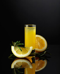 Traditional homemade lemon liqueur limoncello on the black background.