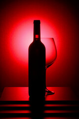 Bottle of red wine and an empty glass.